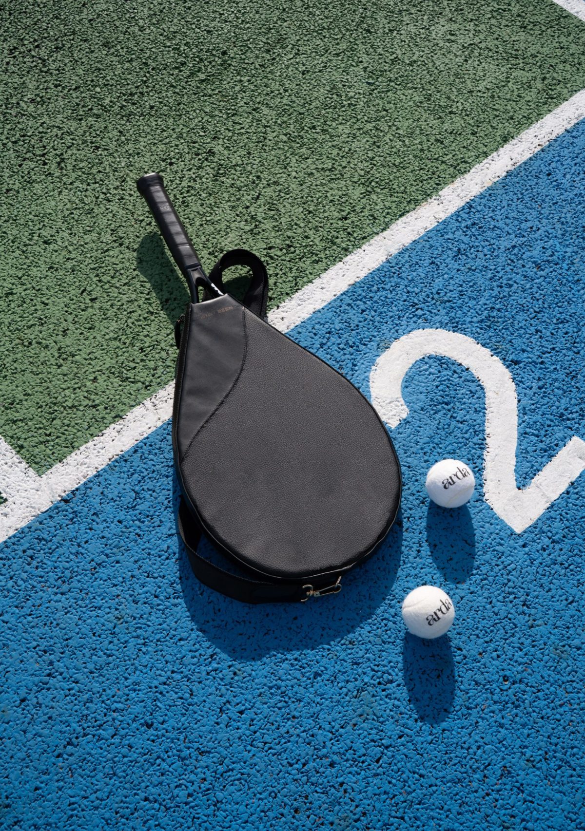 Black paddle bag made from beer grain bio-leather on colorful court